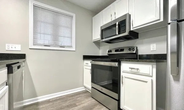 a kitchen with stainless steel appliances granite countertop a stove microwave and refrigerator