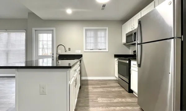 a kitchen with stainless steel appliances granite countertop a refrigerator a sink and a stove