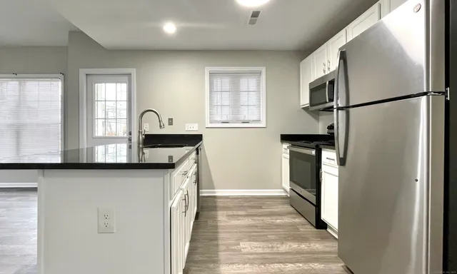 a kitchen with stainless steel appliances granite countertop a refrigerator a sink and a stove