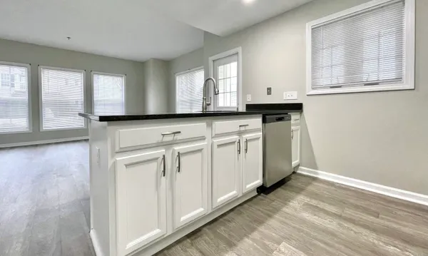 a kitchen with granite countertop white cabinets and white appliances