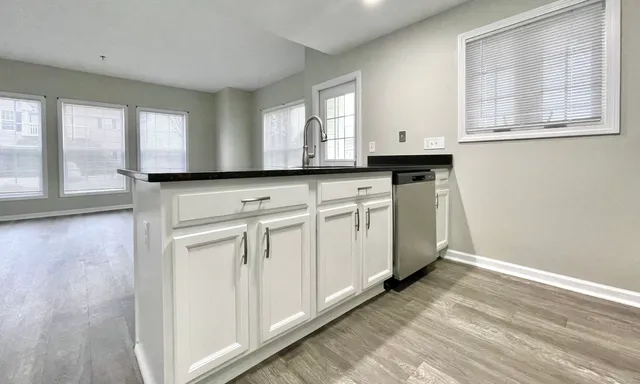 a kitchen with granite countertop white cabinets and white appliances