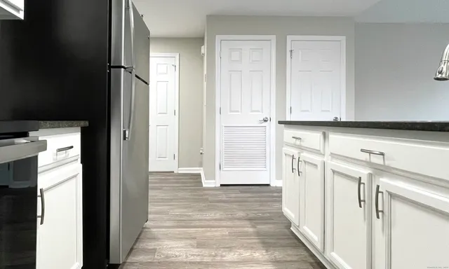 a view of a kitchen with white cabinets