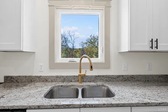 a kitchen with granite countertop a sink and a window
