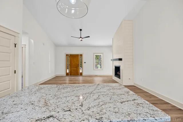 a view of a livingroom with a chandelier and wooden floor