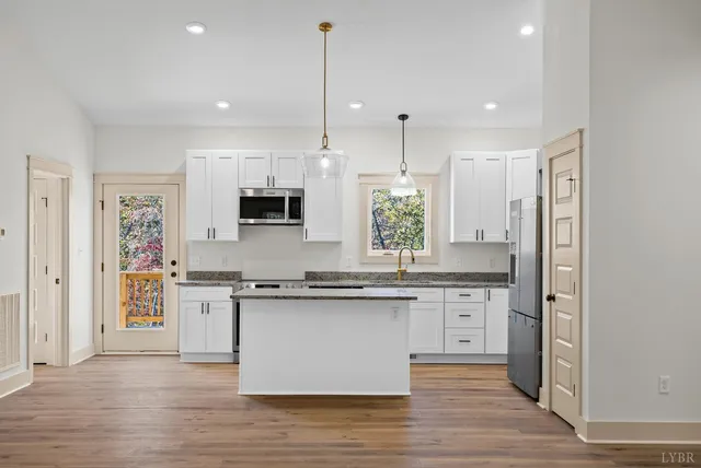 a large kitchen with stainless steel appliances granite countertop a stove and a sink