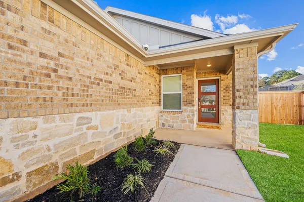 a kitchen with stainless steel appliances a stove a sink a refrigerator cabinets and couches with wooden floor