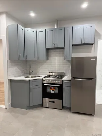 a kitchen with granite countertop white cabinets and stainless steel appliances
