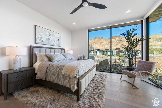 3558 South Cypress Road Hurricane, UT 84737 - Photo 23 of 57 Bedroom with ceiling fan, a mountain view, access to exterior, expansive windows, and wood-type flooring