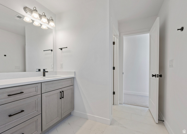 11214 South Easy Bee Road, Unit 270 South Jordan, UT 84009 - Photo 26 of 31 Bathroom vanity featuring light-toned cabinetry, a white countertop, and a single undermount sink with a matte black faucet