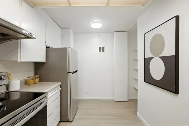 a kitchen with a refrigerator sink and cabinets