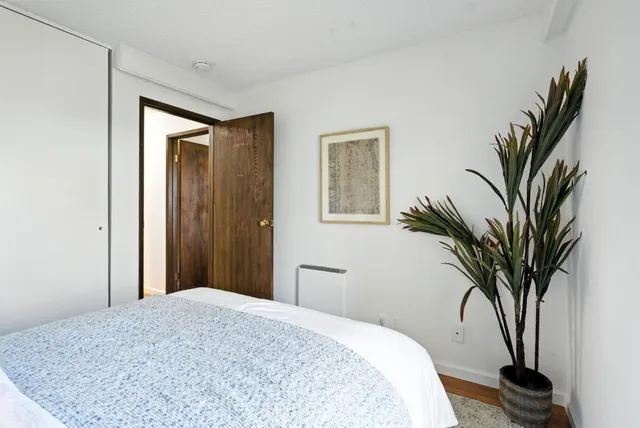 a bedroom with a bed and a painting on the wall