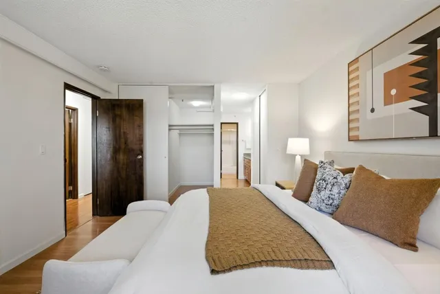 a bedroom with a bed and a painting on the wall