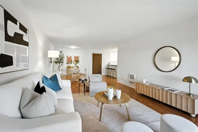 a living room with furniture a mirror and a fireplace