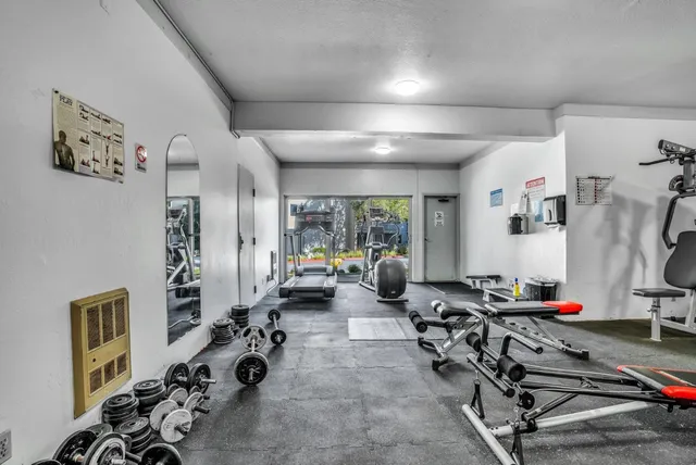 an aerial view of a residential apartment building with a yard and parking spaces
