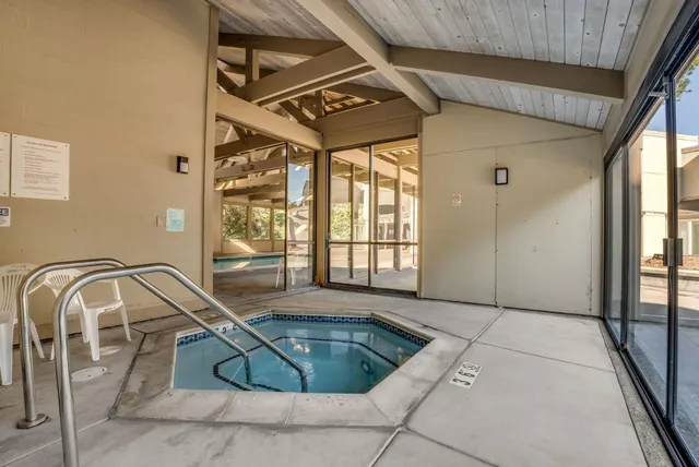 an aerial view of a residential apartment building with a yard and parking spaces
