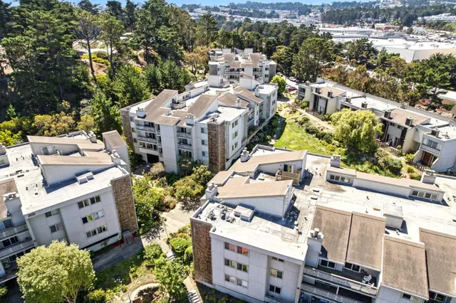 an aerial view of a building with garden space and street view
