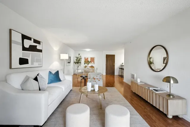 a living room with furniture a mirror and a table