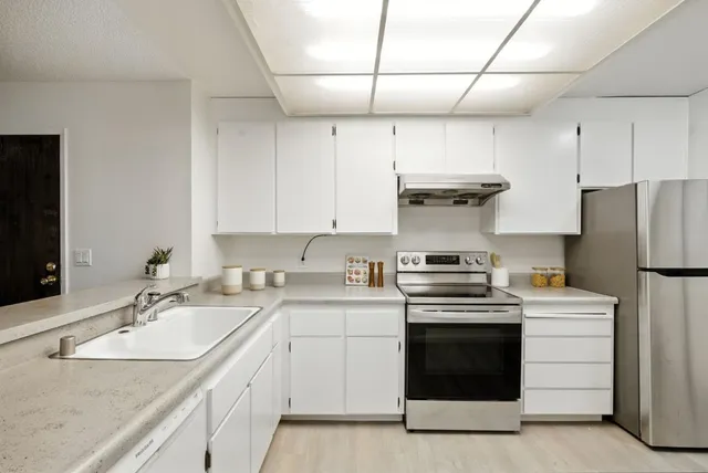 a kitchen with a stove sink and refrigerator