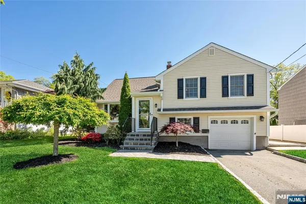 a front view of a house with a yard and trees