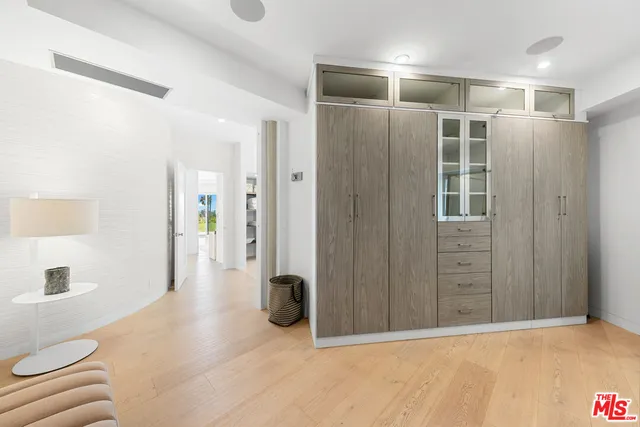 a bedroom with a bed a chair and a large window