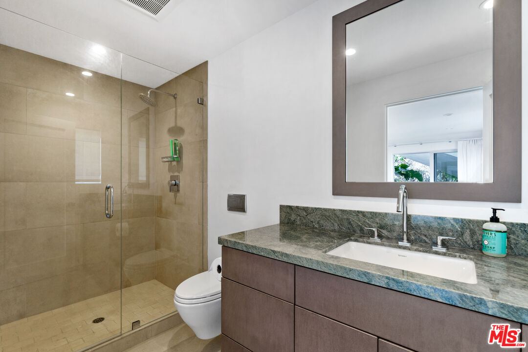 6375 Gayton Place Malibu, CA 90265 - Photo 41 of 49 a bathroom with a granite countertop sink a toilet a mirror and shower