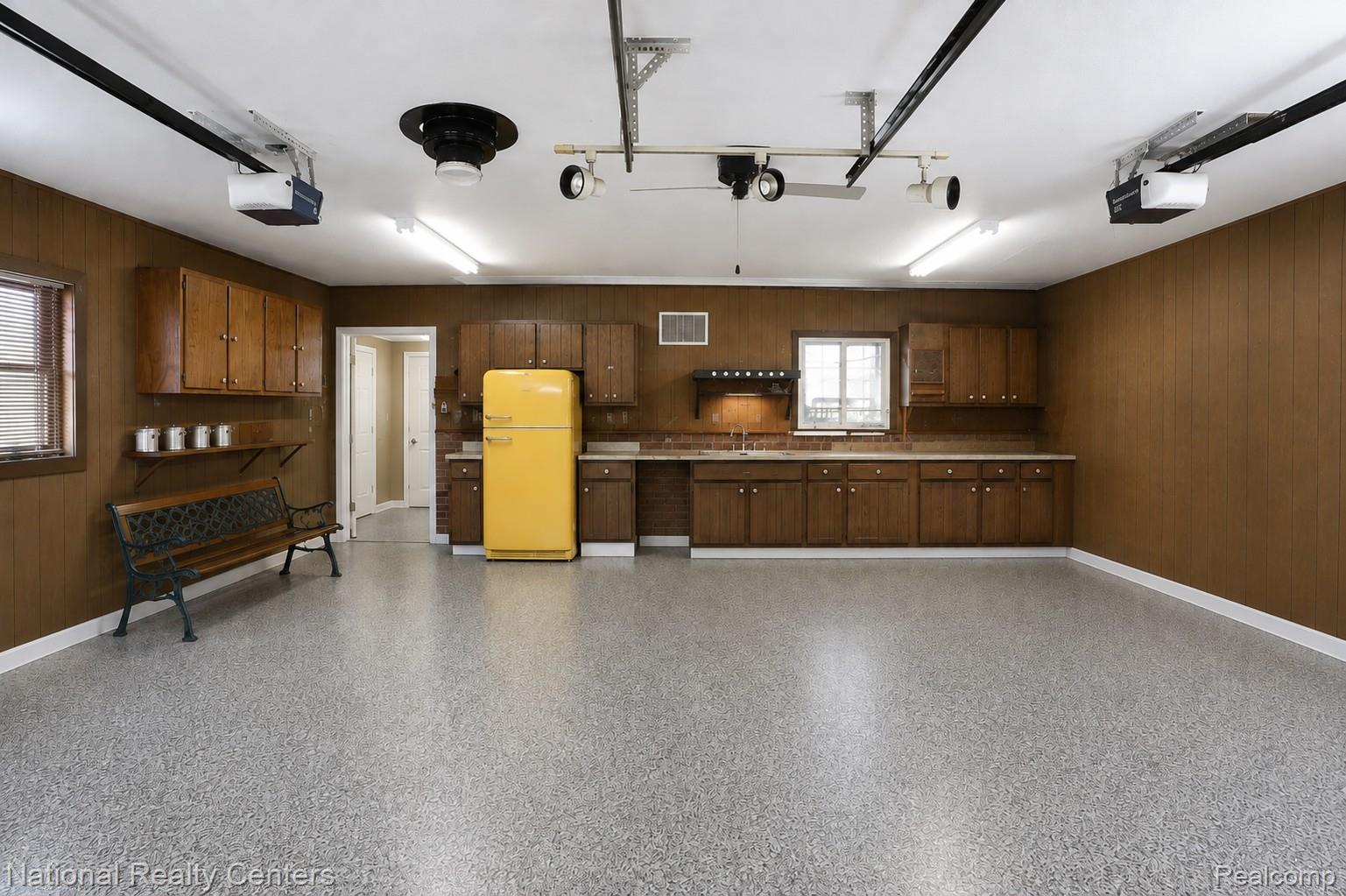 127 West Albain Road Petersburg, MI 49270 - Photo 61 of 61 Epoxy-coated flooring, built-in cabinetry, overhead lighting, garage door openers, and wood paneling
