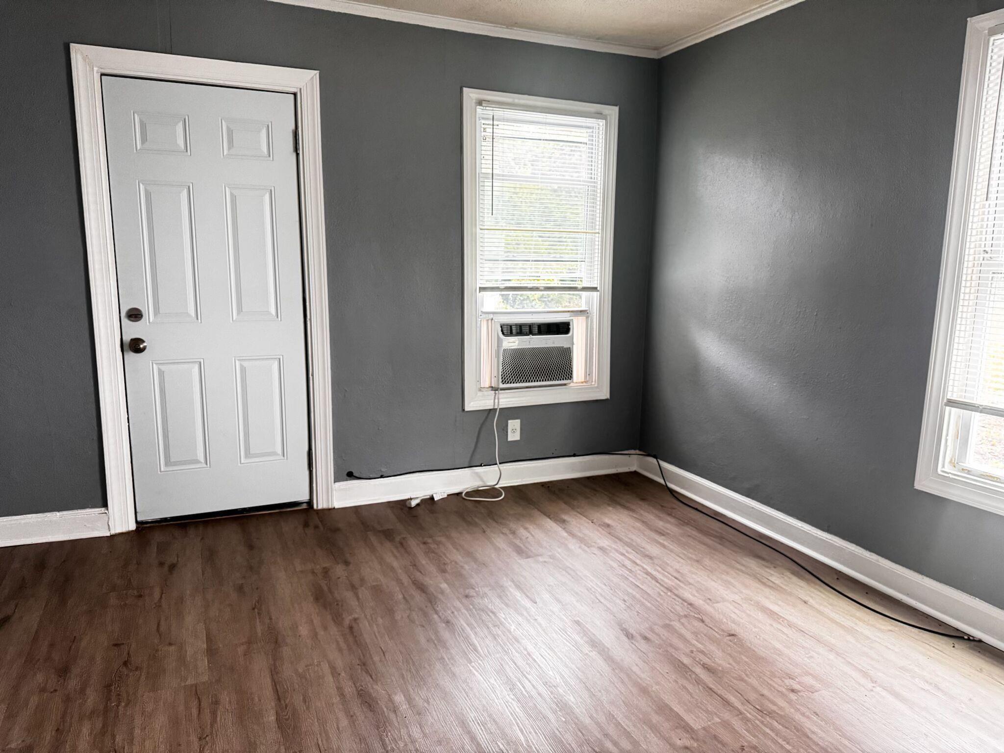 1411 Ragan Street Memphis, TN 38106 - Photo 3 of 6 Unfurnished room with crown molding, dark hardwood / wood-style floors, and cooling unit