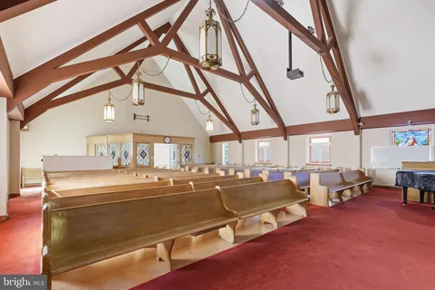 a room with lots of white furniture and a large window
