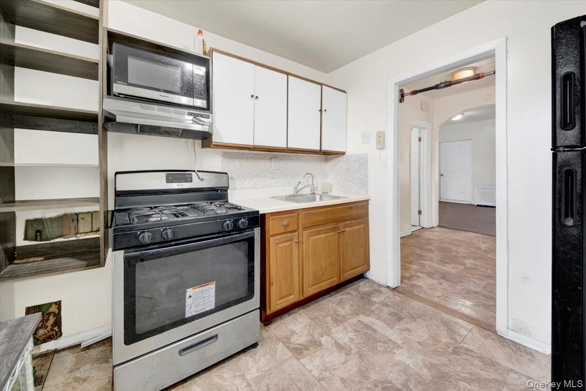 1238 Colgate Avenue Bronx, NY 10472 - Photo 9 of 20 a kitchen with stainless steel appliances granite countertop a stove and a microwave