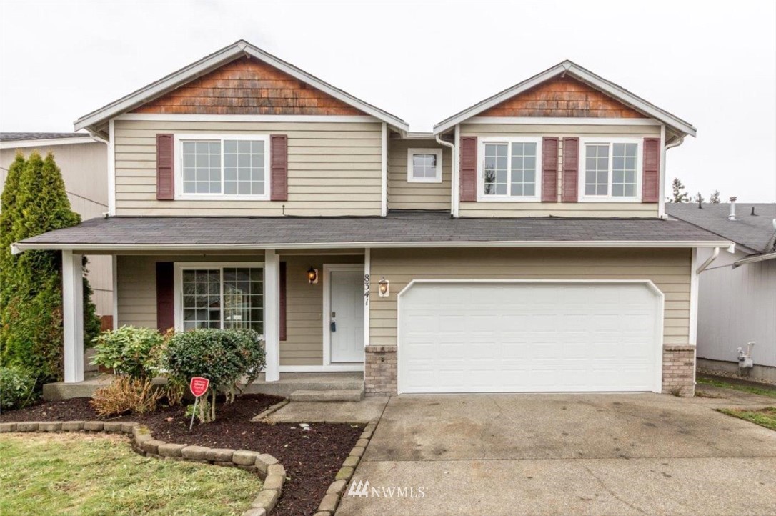 a front view of a house with a yard and garage