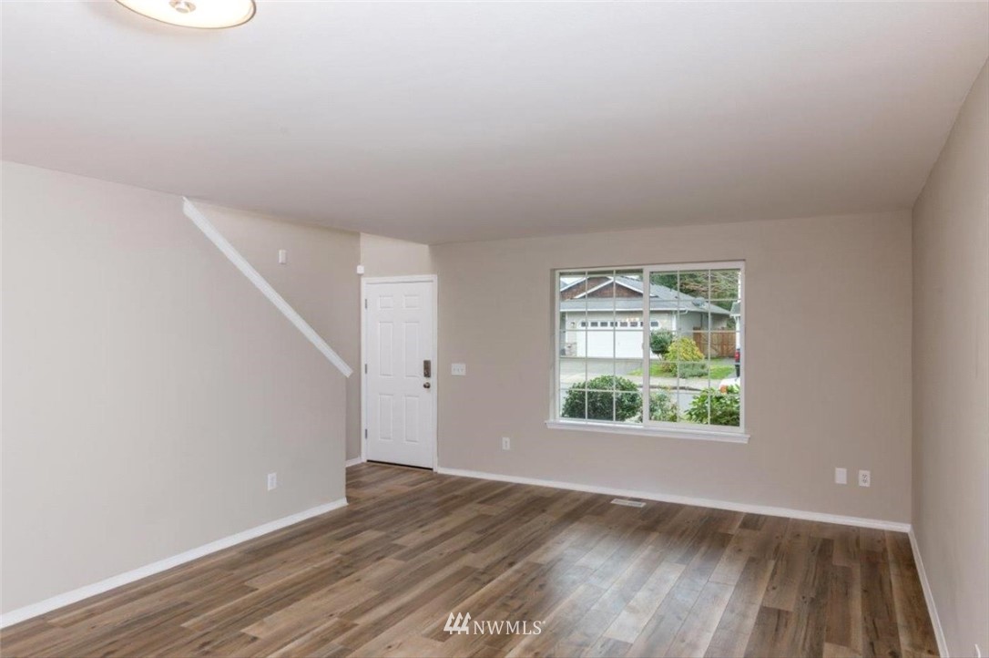8341 49th Loop Southeast Olympia, WA 98513 - Photo 3 of 25 an empty room with wooden floor and windows
