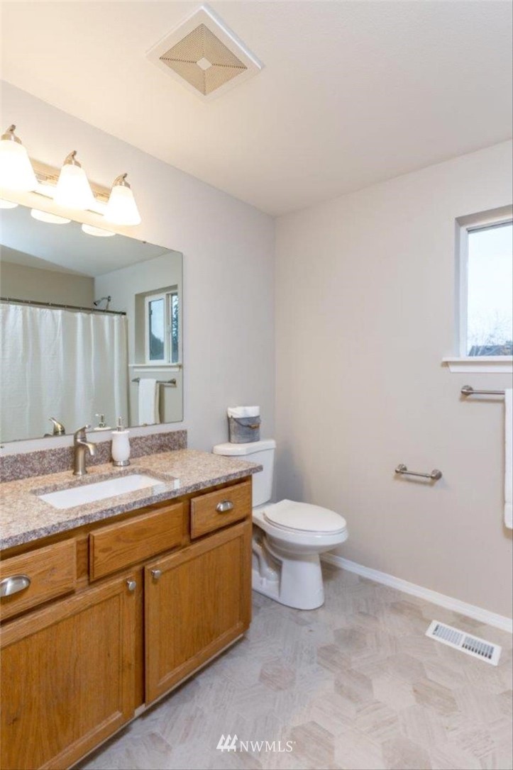 8341 49th Loop Southeast Olympia, WA 98513 - Photo 21 of 25 a bathroom with a granite countertop toilet sink mirror and vanity