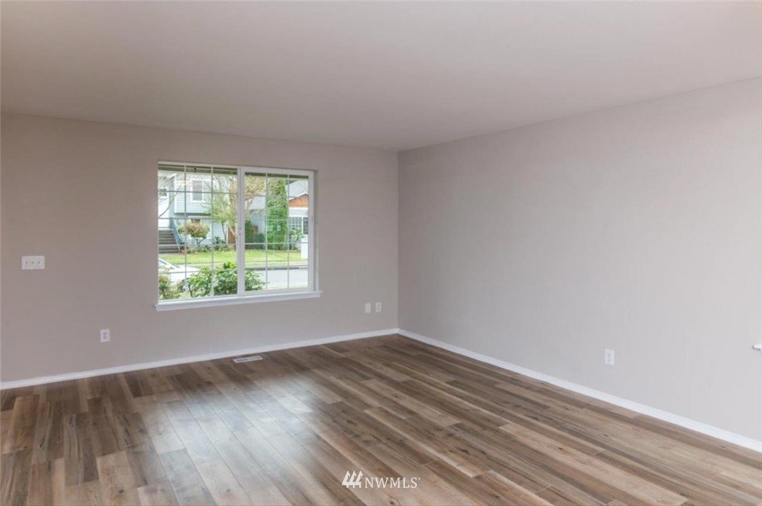 8341 49th Loop Southeast Olympia, WA 98513 - Photo 4 of 25 an empty room with wooden floor and windows