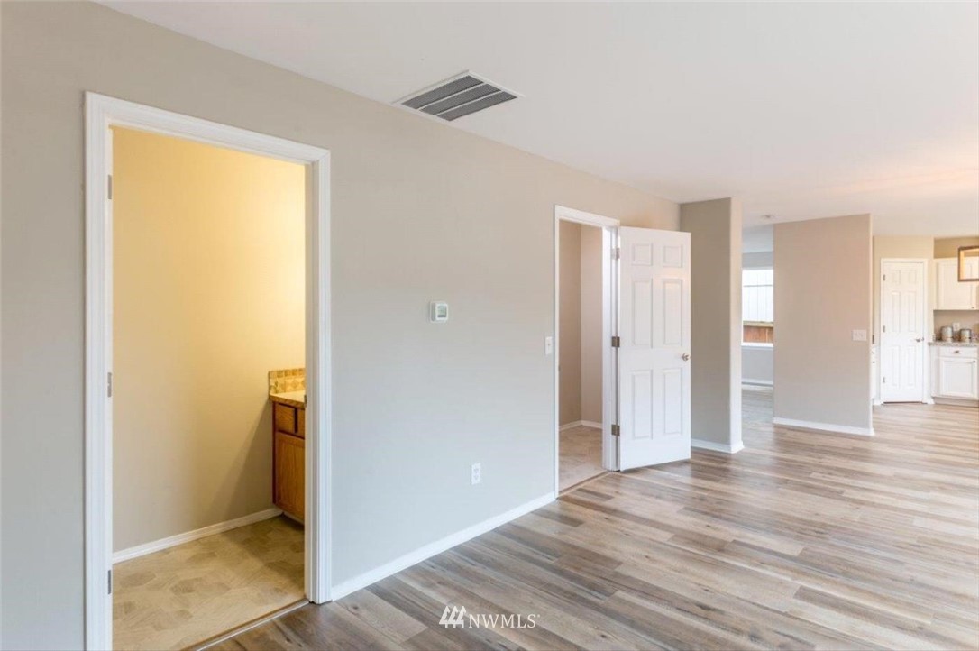 8341 49th Loop Southeast Olympia, WA 98513 - Photo 7 of 25 a view of a room with wooden floor and a bathroom