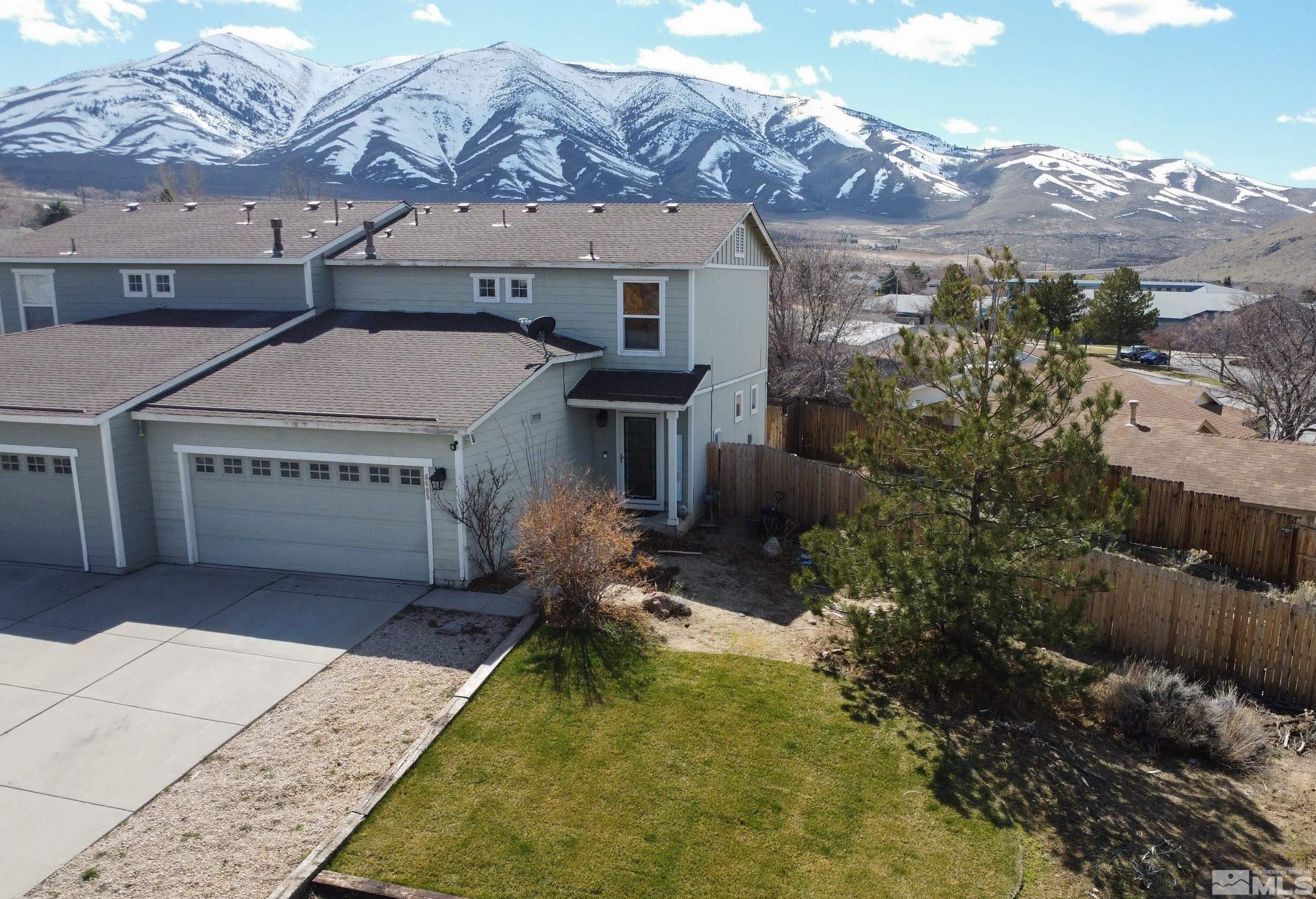 a aerial view of a house with a yard and mountain view in back