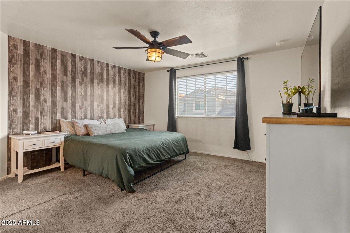 11452 West St John Road Surprise, AZ 85378 - Photo 11 of 29 a spacious bedroom with a bed and a chandelier
