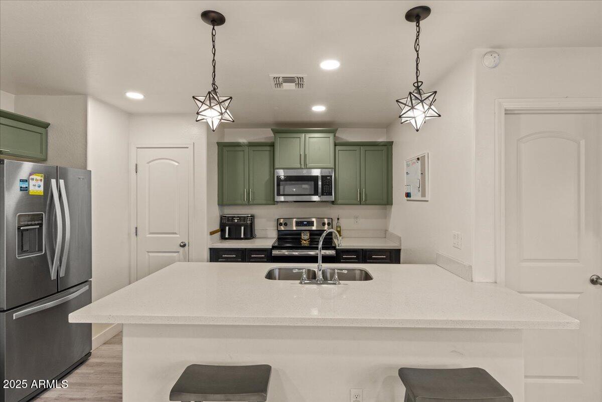 11452 West St John Road Surprise, AZ 85378 - Photo 7 of 29 a kitchen with kitchen island white cabinets and stainless steel appliances