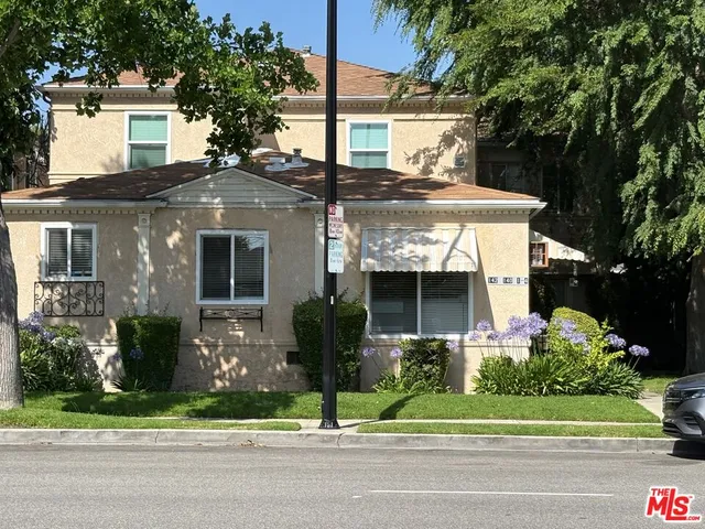 a front view of house with a garden