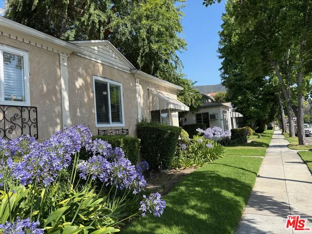 a front view of a house with a yard and fountain