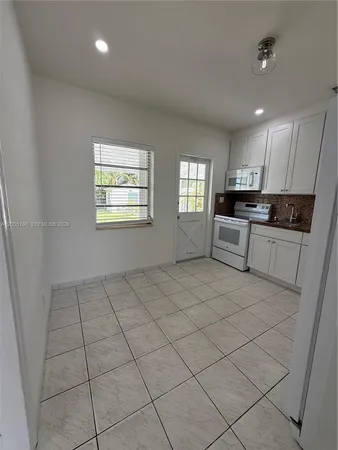 an empty room with windows and ceiling fan