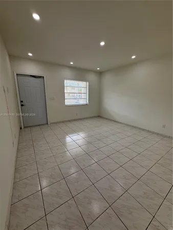 an empty room with white walls and tiles