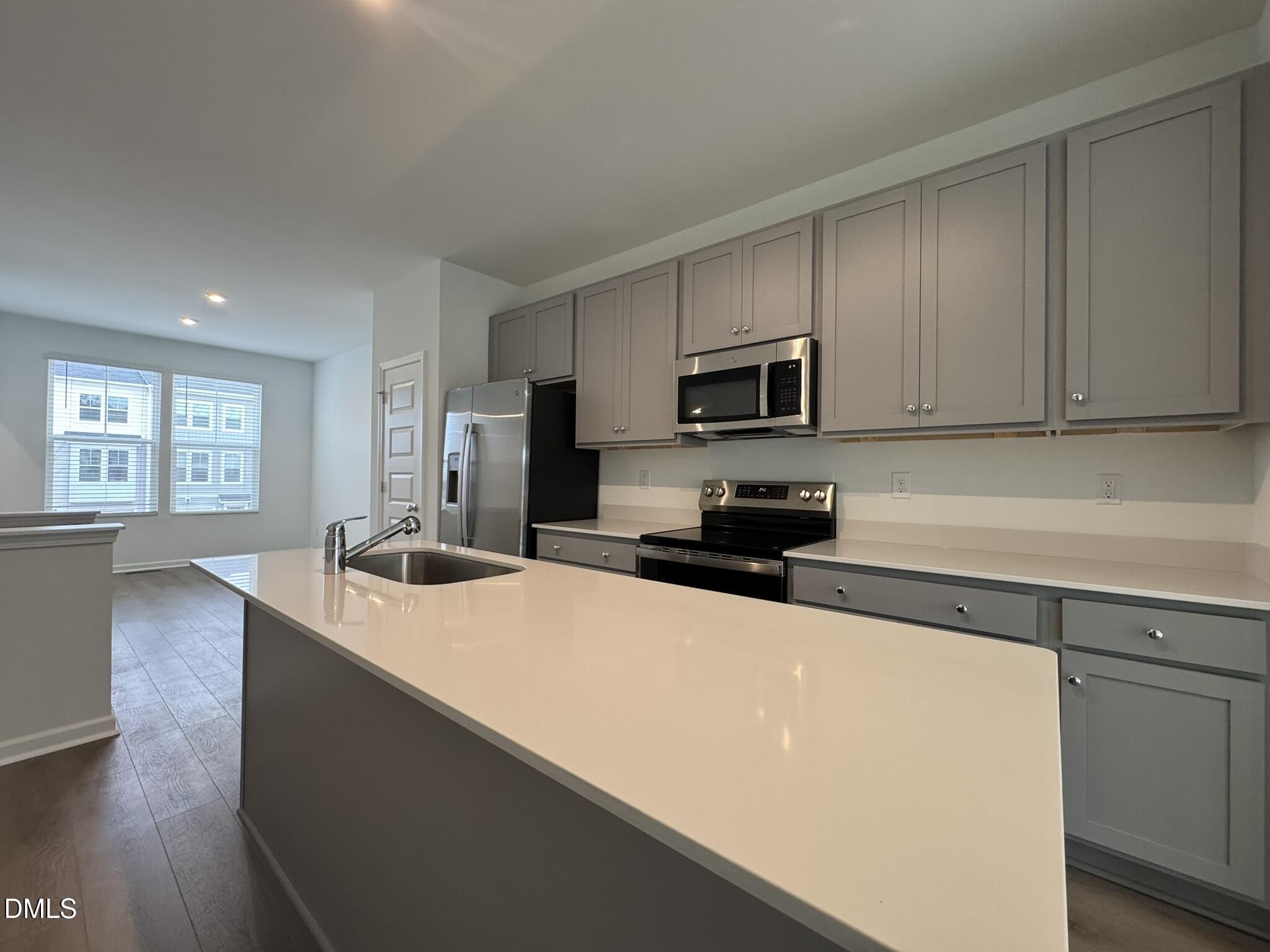 3312 Bomore Road Raleigh, NC 27610 - Photo 5 of 20 a kitchen with stainless steel appliances a sink a stove a microwave a sink a refrigerator and cabinets