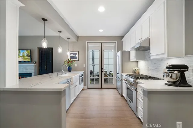 a large white room with a large window and stainless steel appliances