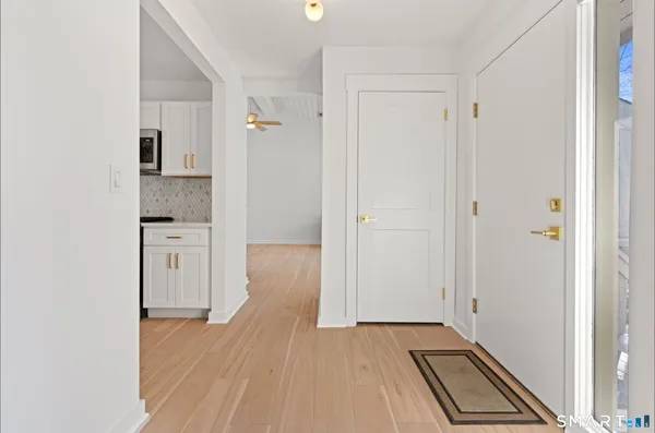 a view of a kitchen from the hallway with wooden floor