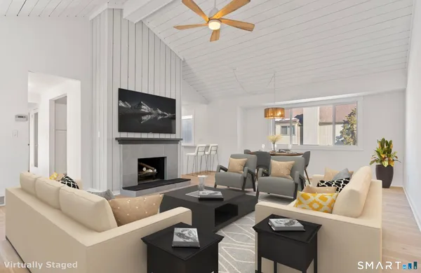 a living room with furniture a fireplace and a flat screen tv