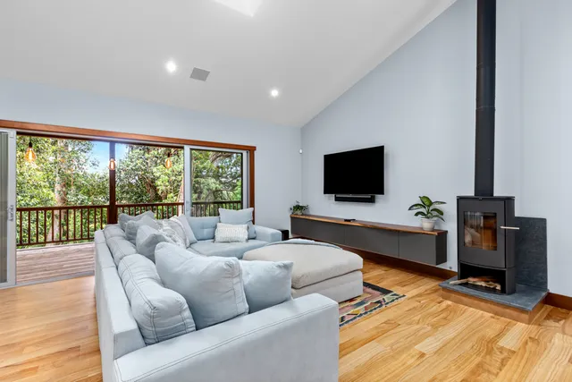 a living room with furniture a flat screen tv and a floor to ceiling window