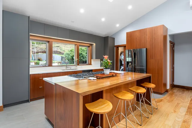 a kitchen with stainless steel appliances granite countertop a table chairs and a refrigerator