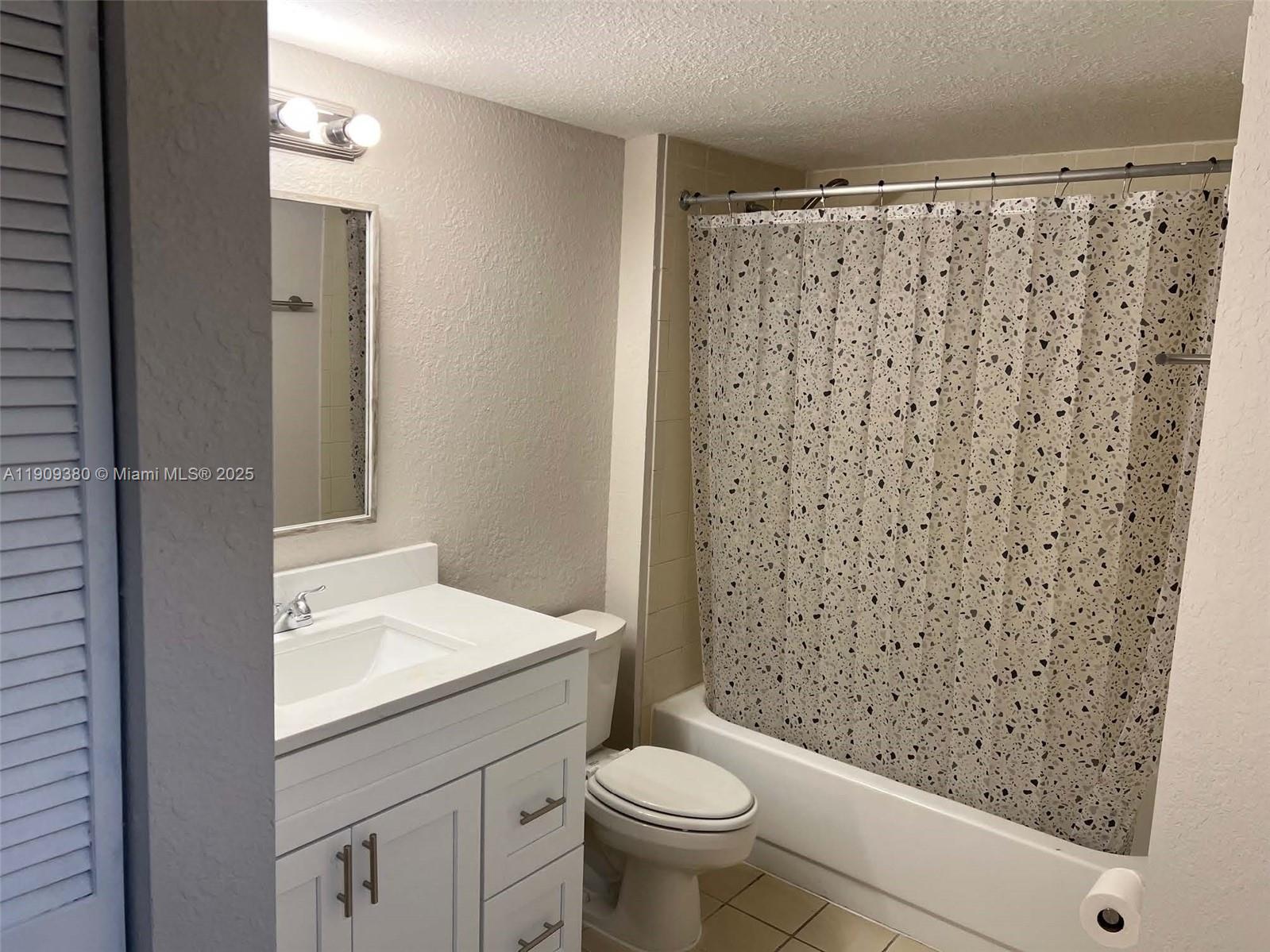 4055 West McNab Road, Unit H103 Pompano Beach, FL 33069 - Photo 11 of 14 a bathroom with a sink a toilet and shower curtain