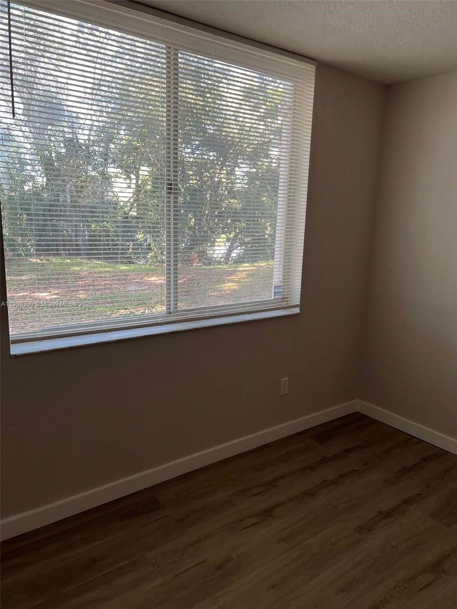 4055 West McNab Road, Unit H103 Pompano Beach, FL 33069 - Photo 8 of 14 a view of a room that has wooden floor and a window