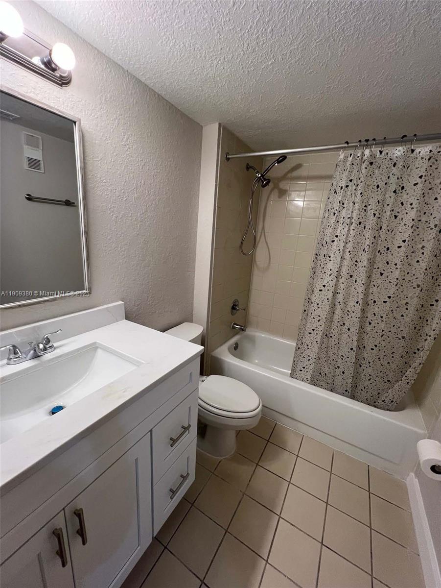 4055 West McNab Road, Unit H103 Pompano Beach, FL 33069 - Photo 10 of 14 a bathroom with a sink a toilet and shower